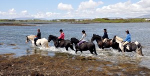 Riders trekking along the shores of Carrowholly